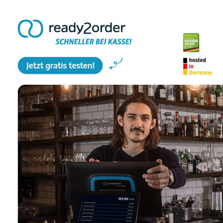 im bild ist ein mann mit einem kassensystem von ready2order zu sehen, der gut gelaunt die kasse bedient